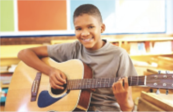 child with a smile holding a guitar